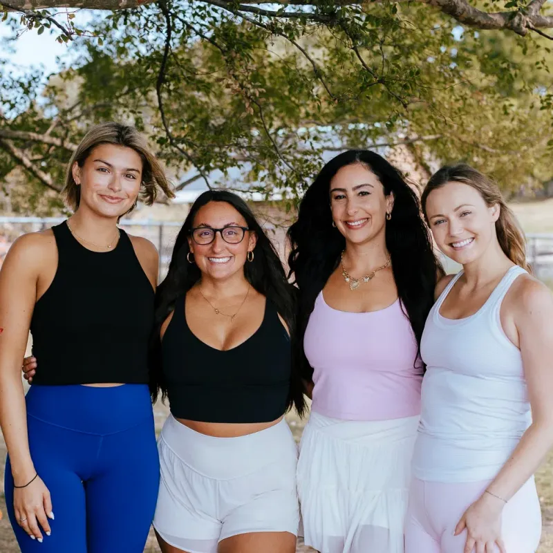 Four women standing together outdoors at an Evolving Heart membership gathering.